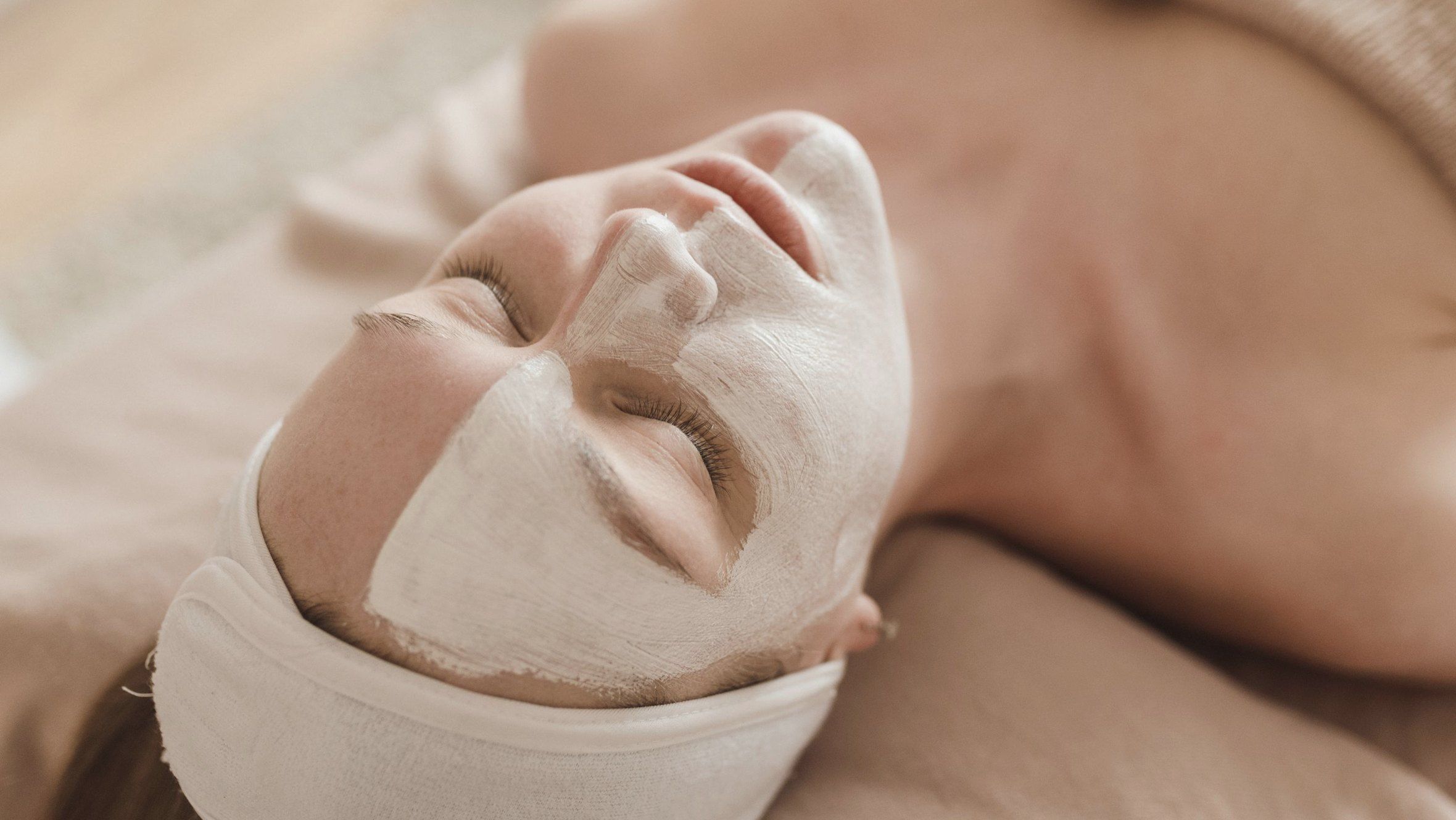 Klientka s čisticí maskou na obličeji odpočívá na lůžku